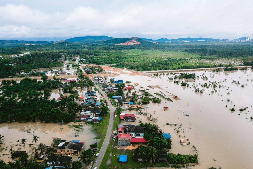 Aerial shot showing flood-affected village in Kijal, Malaysia, surrounded by water and greenery.